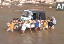 जम्मू कश्मीर में कंधे पर ऑटो लादकर तवी नदी पार कर रहे लोग